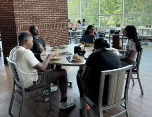 Mentor sits with students of the Summer Transportation Institute.